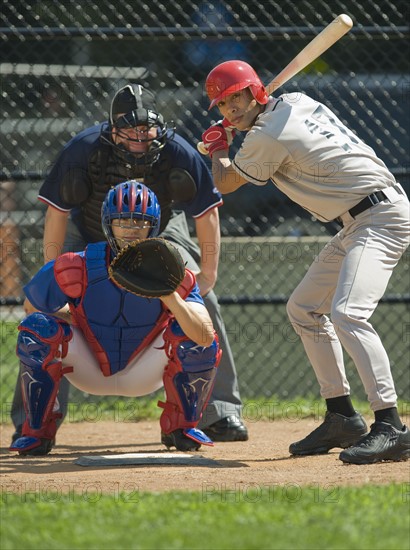 Baseball pitcher, batter and umpire in ready position.