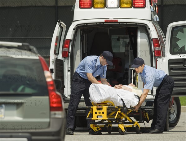 EMTs loading patient into ambulance.