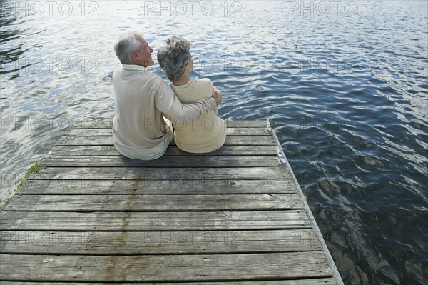 Senior couple hugging on dock.