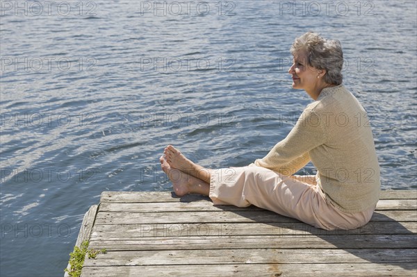 Senior woman sitting on dock.