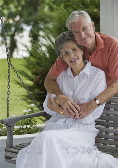 Senior couple sitting on porch swing.