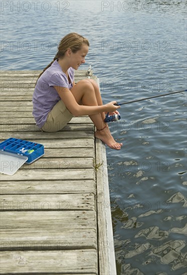 Girl fishing off dock.