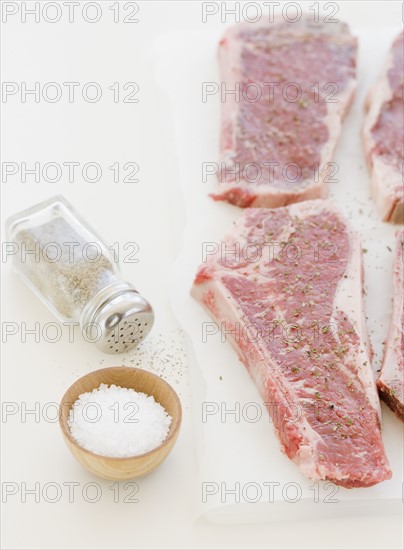 Close up of raw steaks and seasoning. Date : 2008