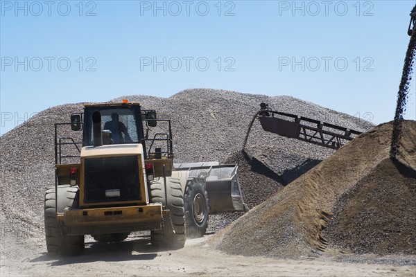 Bucket loader moving pile of gravel. Date : 2008