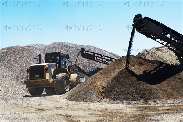 Bucket loader moving pile of gravel. Date : 2008