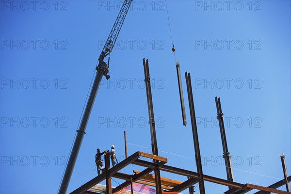 Low angle view of construction workers on beam. Date : 2008