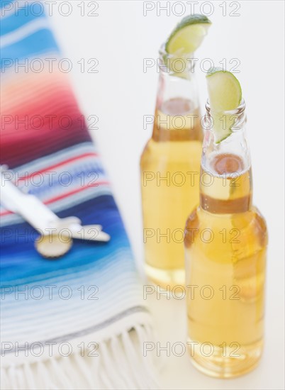 Refreshing beer bottles garnished with lime slices. Date : 2008