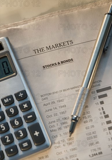 Close up of pen, calculator and financial pages. Date : 2008