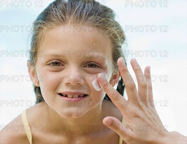 Mother applying sunscreen to daughter’s face. Date : 2008