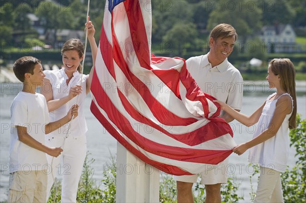 Family raising American flag together.