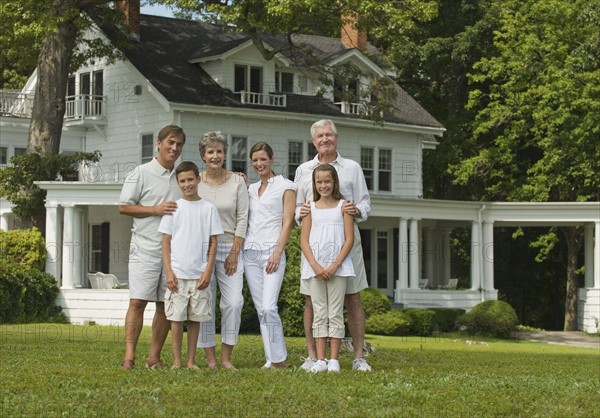 Multi-generational family posing in front yard.