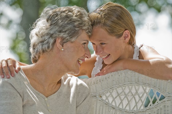 Grandmother and granddaughter smiling at each other.