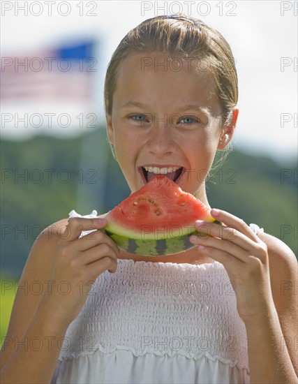 Girl eating watermelon outdoors.