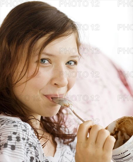 Teenage girl eating from ice cream carton. Date : 2008