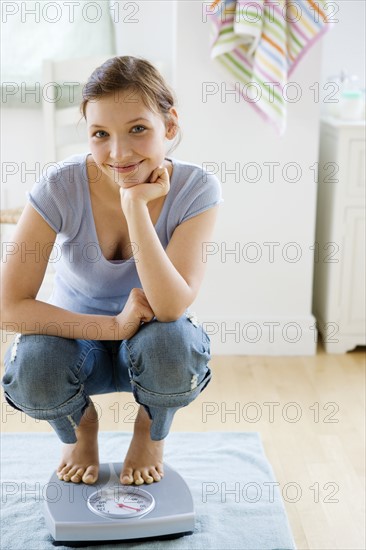 Teenage girl standing on bathroom scale. Date : 2008