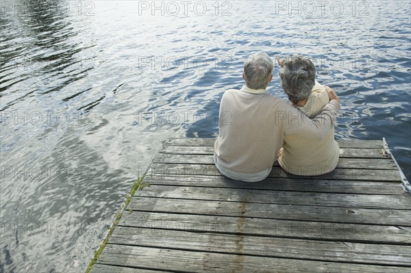 Senior couple hugging on dock.