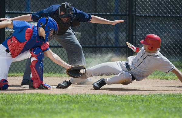 Baseball player sliding into home plate.