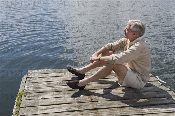 Senior man sitting on dock.