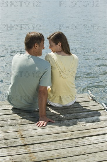 Couple sitting on dock.