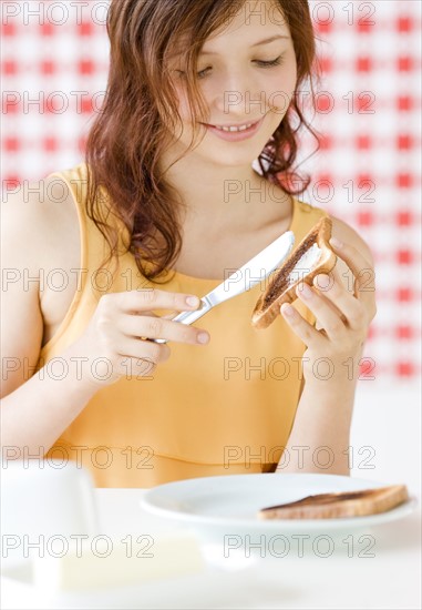 Teenage girl making toast. Date : 2008