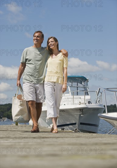 Couple walking on boat dock.