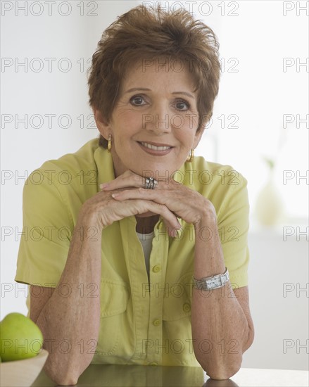 Portrait of senior woman leaning on counter.