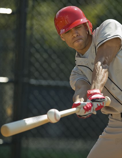 Baseball batter hitting ball.