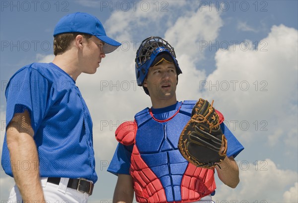 Baseball pitcher and catcher conferring about pitch.