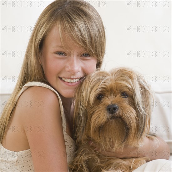 Girl hugging dog.