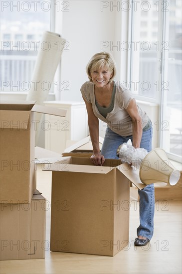 Woman unpacking moving boxes.