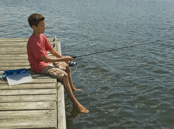 Boy fishing off dock.