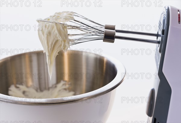 Close up of whipped cream in mixer beaters.