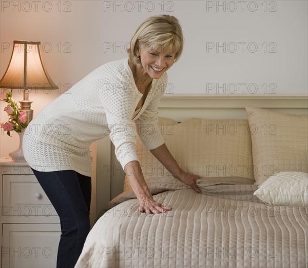 Woman making bed.
