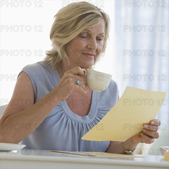 Woman reading letter at home.