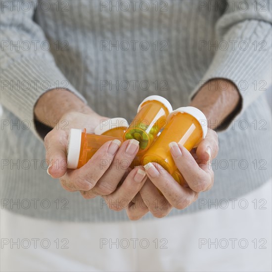 Senior woman holding prescription bottles.