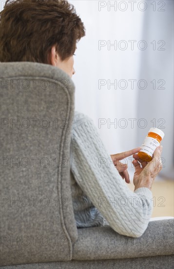 Senior woman reading prescription label.