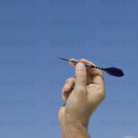 Close up of hand holding dart.
