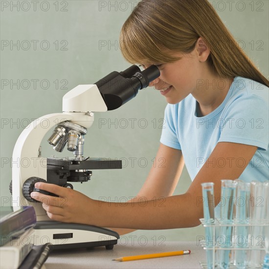 Girl using microscope.