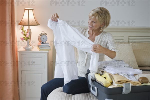 Woman packing suitcase.