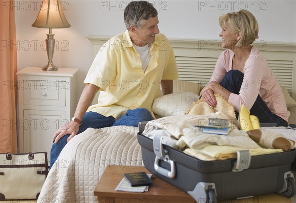 Couple resting on hotel bed.