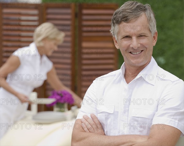 Couple preparing outdoor restaurant for service.