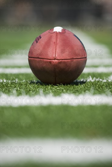 Close up of football on yard line marker.