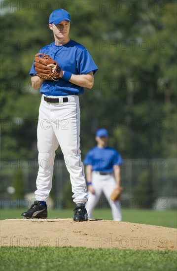 Baseball pitcher preparing to pitch ball.