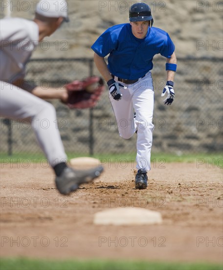 Baseball player trying to steal base.