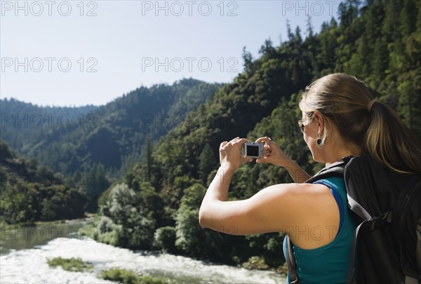 Hiker photographing river scene. Date : 2008
