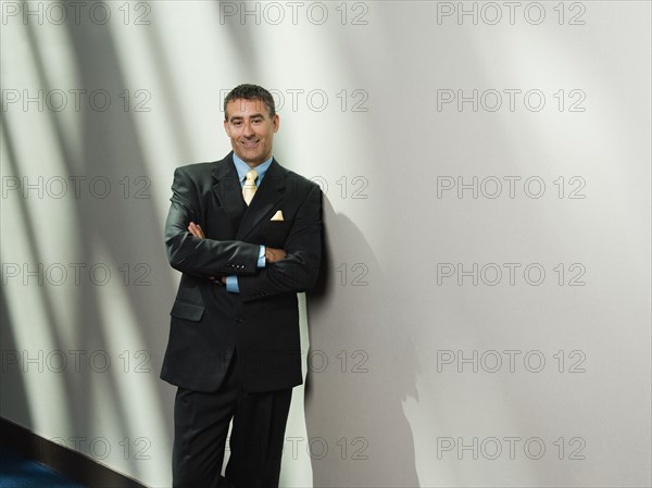 Businessman leaning against wall. Date : 2008