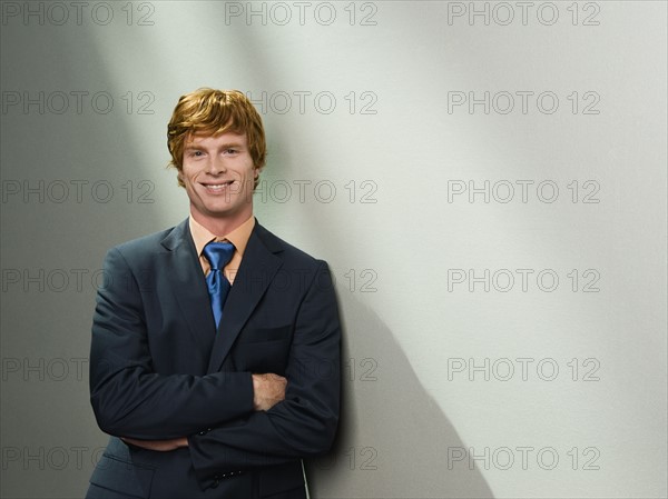 Confident businessman leaning against wall. Date : 2008