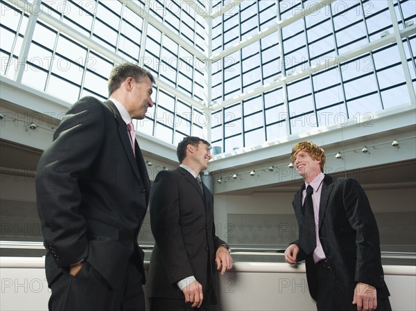 Businessmen socializing in convention center atrium. Date : 2008