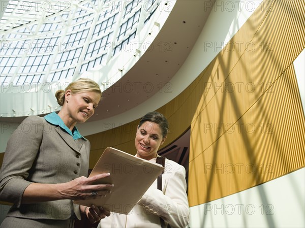 Businesswomen discussing file in office. Date : 2008