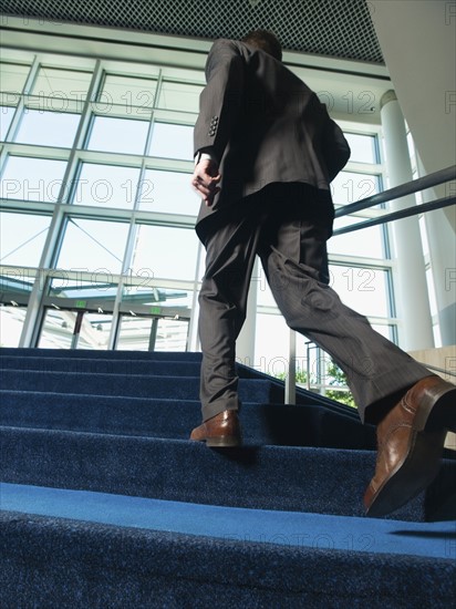 Businessman ascending office building stairs. Date : 2008